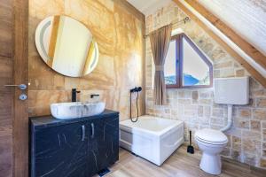 a bathroom with a sink and a toilet and a mirror at VILA K3 Komarnica in Šavnik +16 photos