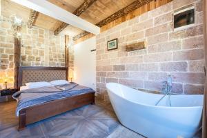 a bathroom with a tub next to a brick wall at VILA K3 Komarnica in Šavnik