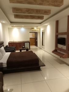 a bedroom with a bed and a television in it at Hotel Bouery in An Nā‘ūrah