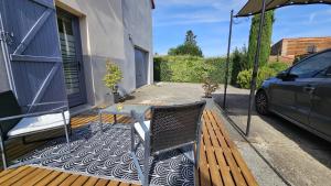 a patio with a table and a chair on a deck at Chambre privé climatisé in Vertaizon
