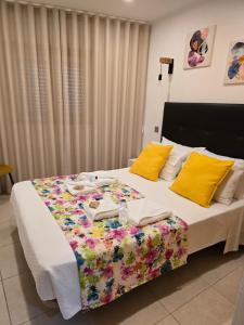 a bedroom with a large bed with yellow pillows at LC's Guesthouse in Lagos
