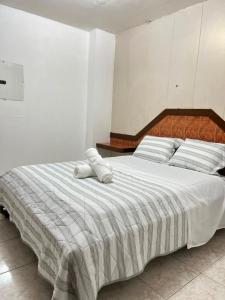a bedroom with a large bed with white sheets at Pension Calidonia in Panama City