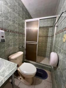 a bathroom with a toilet and a shower and a sink at Pension Calidonia in Panama City
