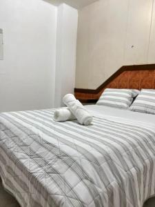 a white bed with two white towels on it at Pension Calidonia in Panama City