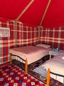 ein Zimmer mit zwei Betten in einem Zelt in der Unterkunft Authentic Desert Camp - Al Wasil in Al Wāşil