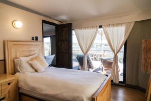 a bedroom with a large bed and a balcony at Hotel Omún, San Miguel de Allende in Dolores Hidalgo +28 photos