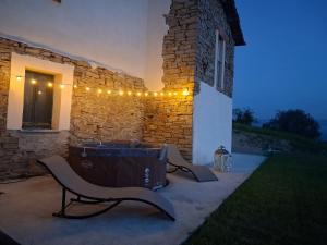 a patio with a bench and lights on a building at Bella vista 2 in Castellino Tanaro