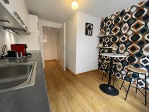 a kitchen with a counter and a table in a room at Retro-Chic Wohnung in der Bregenzer Fußgängerzone in Bregenz