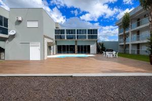 a white building with a patio and a table at Hotel Vanguarda Tapera in Tapera