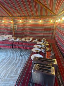 ein Raum mit einem Tisch voller Teller mit Essen in der Unterkunft Authentic Desert Camp - Al Wasil in Al Wāşil