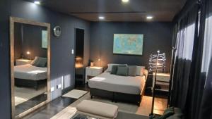 a bedroom with two beds and a mirror at MiCASA in Córdoba