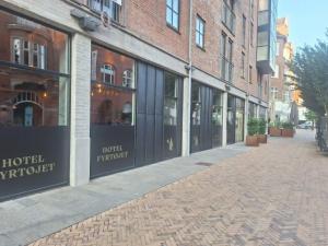 a row of store fronts on a city street at Fyrtojet in Odense +22 photos