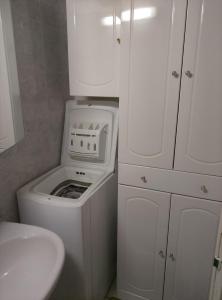 a small bathroom with a washing machine and a sink at Mazet du bonheur in Saint-Martin-de-Brômes
