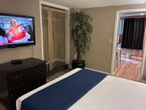 a bedroom with a bed and a flat screen tv at Desert Hills Motel in Las Vegas