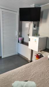 a room with a bed and a television in a room at Recanto da Matriz - Águas da Prata in Águas da Prata