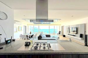 a kitchen and a living room with a stove top at Playa Acapulco Espectacular Apartment in Acapulco