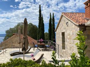 a patio with a table and chairs and umbrellas at Holiday Homes Baučić in Omiš