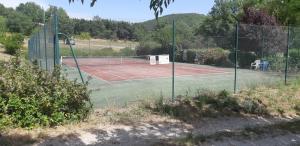 a tennis court with a net on a tennis court at Mazet du bonheur in Saint-Martin-de-Brômes