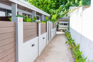 a white fence with wooden doors and potted plants at Lagoon Dhigurah in Dhigurah