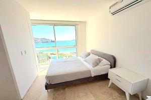 a bedroom with a bed with a view of the ocean at Playa Acapulco Espectacular Apartment in Acapulco +77 photos