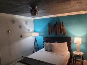 a bedroom with a bed and a blue wall at Desert Hills Motel in Las Vegas +43 photos