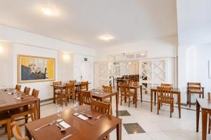 ein Esszimmer mit Holztischen und Stühlen in der Unterkunft Bristol Sabrina Hotel de Charme Joinville in Joinville