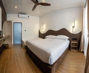 a bedroom with a large bed and a ceiling fan at Lagoon Dhigurah in Dhigurah