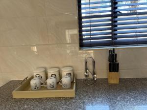 a group of four white vases sitting on a counter at 25 Lillies in Rustenburg