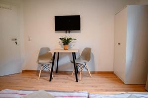 a table and chairs in a room with a tv on the wall at Bergblick Zimmervermietung in Ebensee