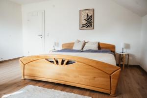 a bedroom with a wooden bed in a white room at Bergblick Zimmervermietung in Ebensee