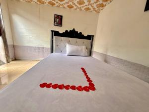 a bed with a red rose decoration on it at Murchison Close Motel in Masindi