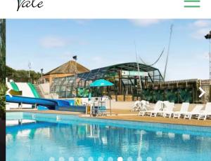 a swimming pool with chairs and a water slide at Beautiful 3 Bed Caravan with Views & Decking in Mortehoe