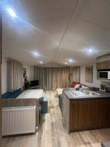 a room with a bed and a kitchen with a sink at Beautiful 3 Bed Caravan with Views & Decking in Mortehoe