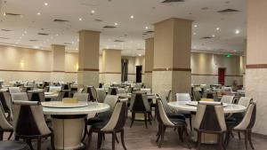 a restaurant with tables and chairs in a room at الارض المتميزة -1 - نبراس الهدى - Nebras ElHoda in Mecca +40 photos