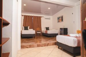 a room with two beds and two chairs at Hotel Crossman in Puerto Ayora +28 photos