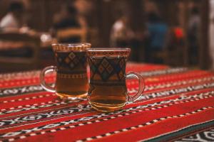 Zwei Biergläser stehen auf einem Tisch. in der Unterkunft Authentic Desert Camp - Al Wasil in Al Wāşil