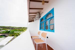 a balcony with chairs and a blue window at Hotel Crossman in Puerto Ayora