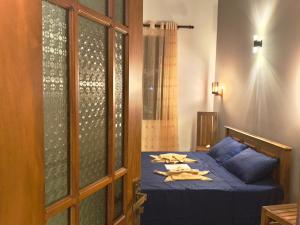a bedroom with a blue bed with towels on it at Domus Taprobana in Dankotuwa