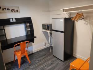 a kitchen with a refrigerator and a table and a chair at Desert Hills Motel in Las Vegas
