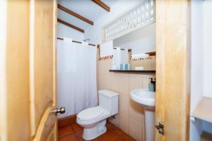 a bathroom with a toilet and a sink at Hotel Crossman in Puerto Ayora