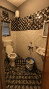 a bathroom with a toilet and a sink at Elyvia Stays in Guwahati