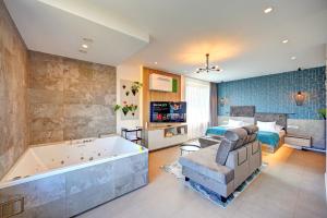 a large bathroom with a tub and a bedroom at Wellness Hotel Fénix in Liberec +61 photos