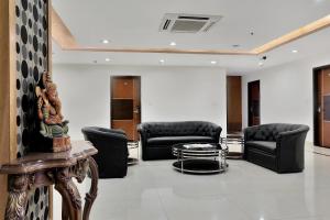 a waiting room with black leather chairs and a table at Super Hotel O Rudra Grand in Hyderabad