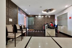 a man sitting at a desk in a lobby at Super Hotel O Rudra Grand in Hyderabad +39 photos