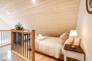 a bedroom with a bed and a wooden wall at Modern Comfort - Spa - Mountain - Chalet ALBA in Saint Come