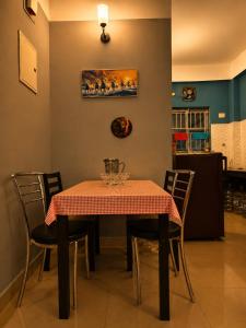 a dining room table with a red and white table cloth at Elyvia Stays in Guwahati