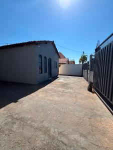 an empty parking lot next to a white building at Refúgio da Sombra House in Rondonópolis