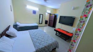 a hotel room with two beds and a flat screen tv at KRISHNA 1 BHK Palace Omaxe in Vrindāvan