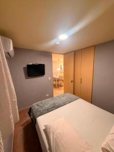 a bedroom with a bed and a tv on the wall at Apto Amoblado Luxury in Bucaramanga