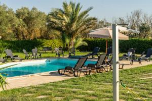 a group of chairs and an umbrella next to a pool at Villa Sofia in Sogliano Cavour